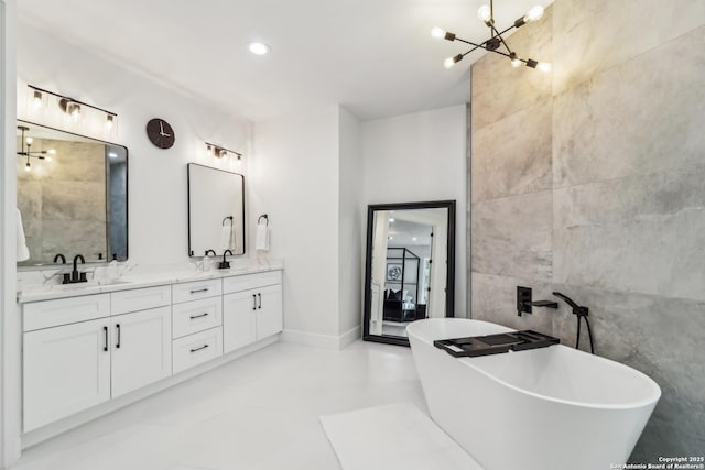 full bathroom featuring a sink, double vanity, a freestanding tub, and tile walls