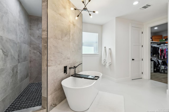 bathroom featuring visible vents, an inviting chandelier, a spacious closet, walk in shower, and a freestanding tub