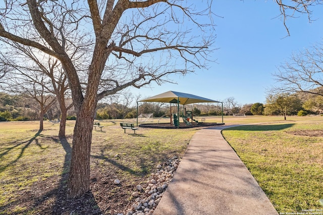 view of property's community with playground community and a yard