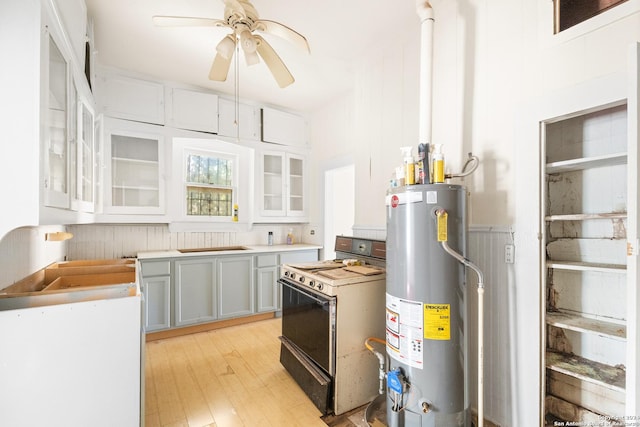 kitchen featuring gas range gas stove, ceiling fan, gray cabinetry, gas water heater, and light hardwood / wood-style floors