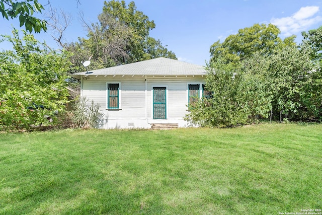 back of house with a lawn