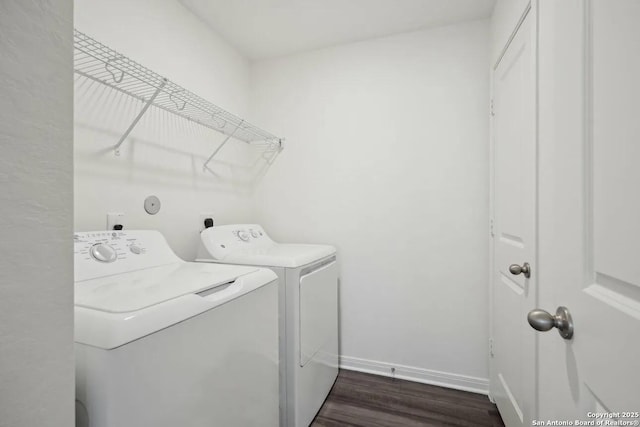 clothes washing area featuring dark hardwood / wood-style floors and separate washer and dryer