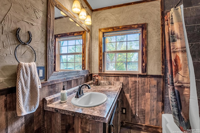 bathroom featuring crown molding, shower / tub combo with curtain, and vanity