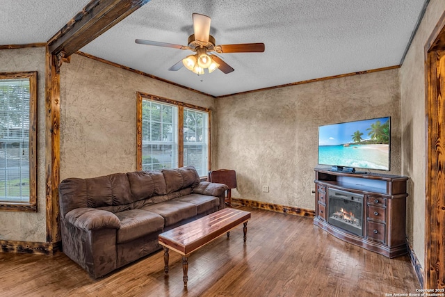 living room with ceiling fan, hardwood / wood-style flooring, ornamental molding, and beamed ceiling