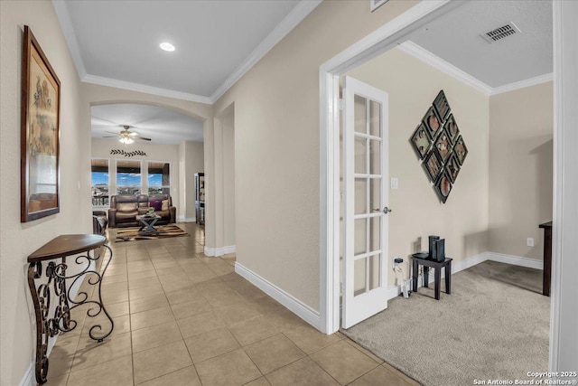 corridor with crown molding and light tile patterned floors