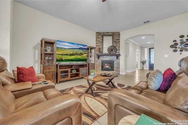 living room with light tile patterned flooring and a stone fireplace