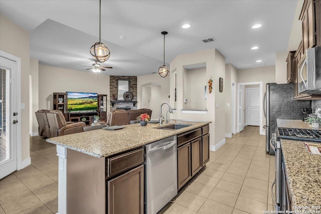 kitchen with sink, dark brown cabinets, a center island with sink, appliances with stainless steel finishes, and pendant lighting