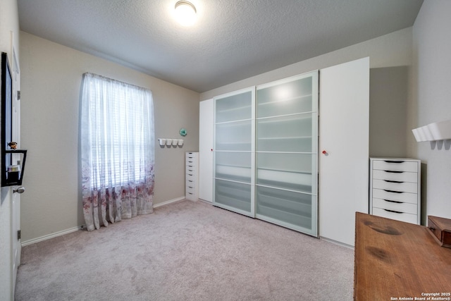 bedroom featuring light colored carpet, a closet, and a textured ceiling