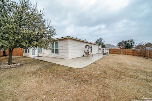 rear view of house with a patio and a lawn