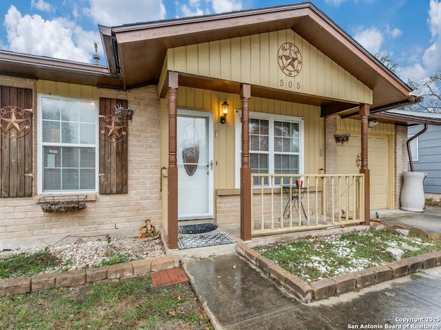 doorway to property with a porch and a garage