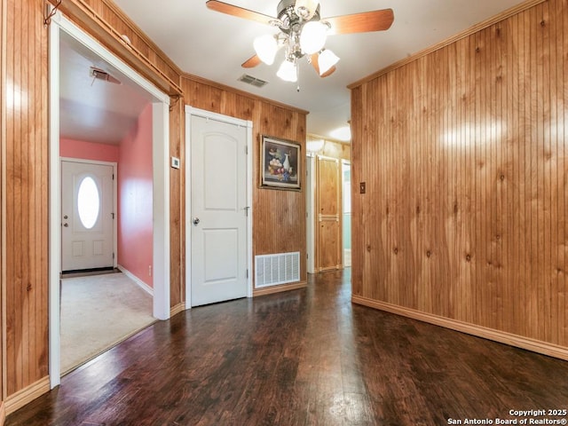 spare room featuring hardwood / wood-style flooring, ceiling fan, and wood walls