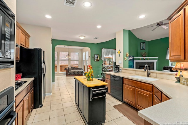 kitchen with butcher block counters, sink, light tile patterned floors, ceiling fan, and black appliances