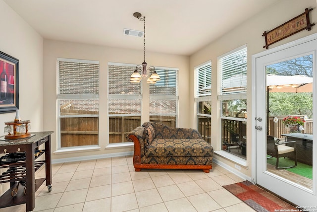 sunroom / solarium featuring a notable chandelier