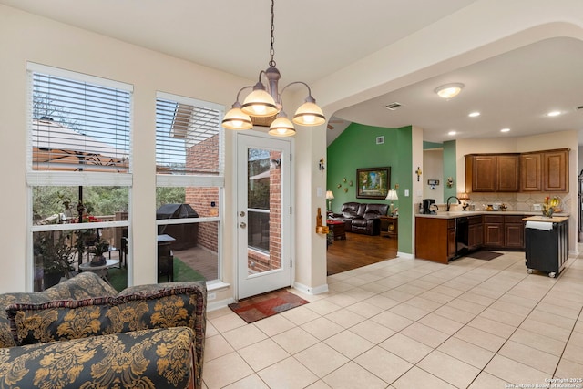 tiled dining space featuring a notable chandelier and a wealth of natural light