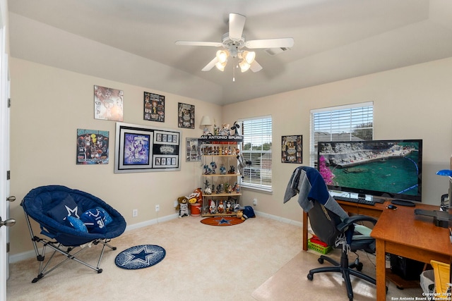 carpeted office featuring ceiling fan and a tray ceiling