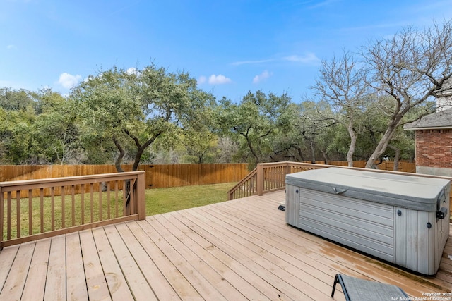 wooden terrace featuring a hot tub and a yard