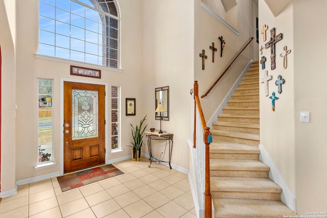 entryway featuring light tile patterned floors and a towering ceiling