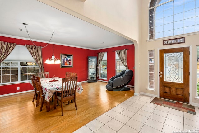 dining space featuring an inviting chandelier, ornamental molding, and wood-type flooring