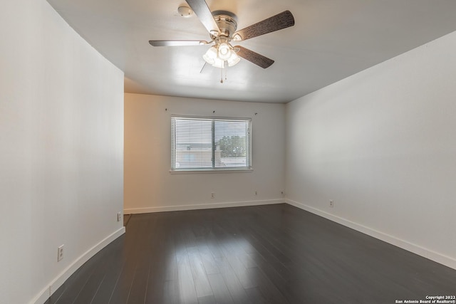 empty room with dark hardwood / wood-style flooring and ceiling fan