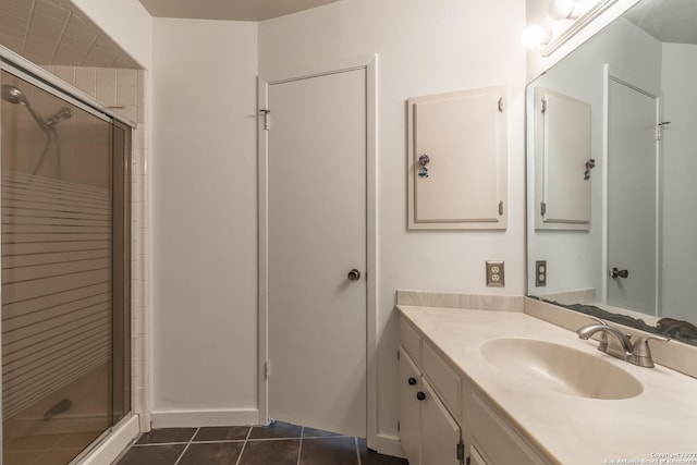 bathroom with walk in shower, vanity, and tile patterned flooring