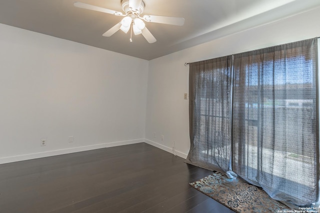 spare room with dark hardwood / wood-style floors and ceiling fan