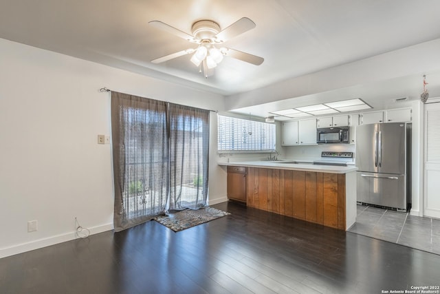 kitchen featuring white cabinetry, dark hardwood / wood-style floors, kitchen peninsula, ceiling fan, and stainless steel appliances