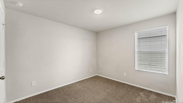 unfurnished room featuring dark carpet