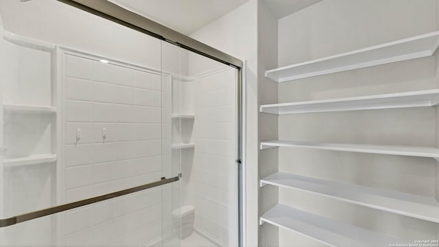 bathroom featuring a shower with shower door