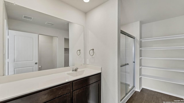 bathroom featuring a shower with door, vanity, and hardwood / wood-style flooring