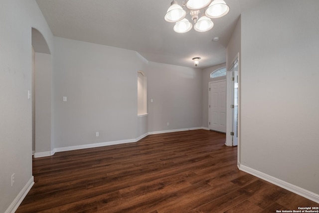 unfurnished room with dark hardwood / wood-style floors and a chandelier