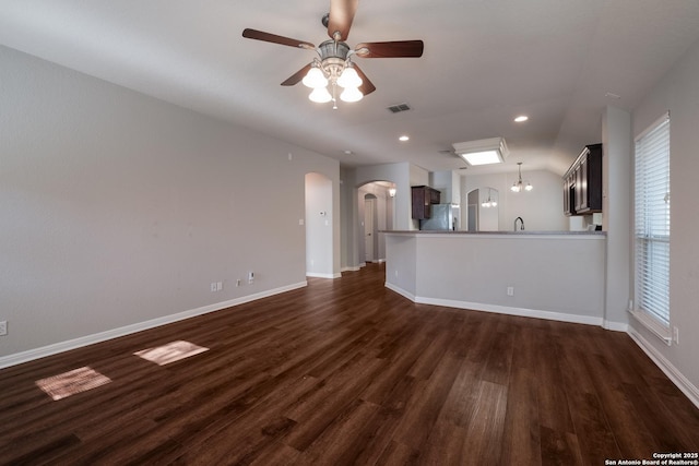 unfurnished living room featuring ceiling fan, lofted ceiling, dark hardwood / wood-style floors, and plenty of natural light