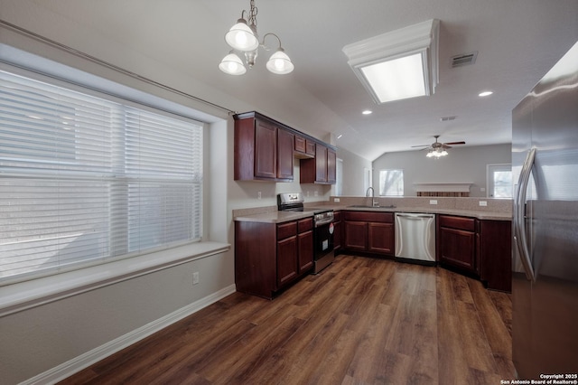 kitchen featuring dark wood-type flooring, sink, vaulted ceiling, pendant lighting, and stainless steel appliances