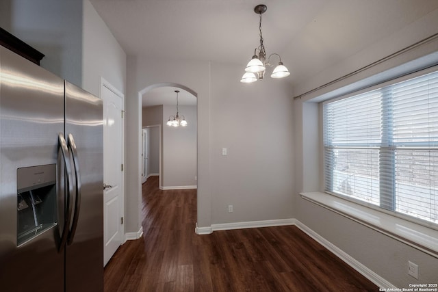 unfurnished dining area featuring dark hardwood / wood-style floors and a chandelier