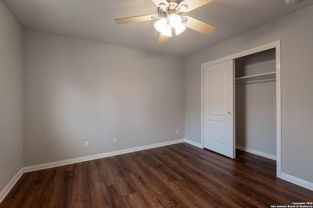 unfurnished bedroom featuring dark hardwood / wood-style flooring, ceiling fan, and a closet