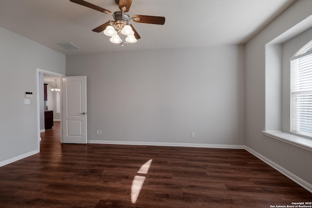 spare room featuring dark wood-type flooring, ceiling fan, and plenty of natural light