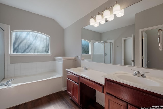 bathroom with hardwood / wood-style flooring, vanity, vaulted ceiling, and shower with separate bathtub