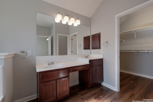 bathroom featuring wood-type flooring, lofted ceiling, and vanity