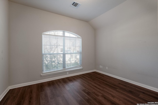 empty room featuring dark wood-type flooring and lofted ceiling