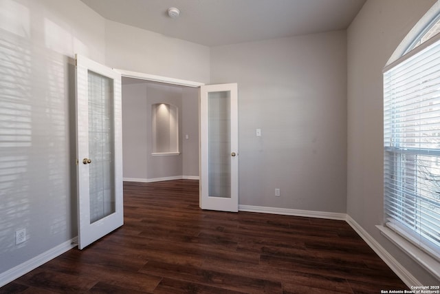 spare room featuring dark hardwood / wood-style floors and french doors