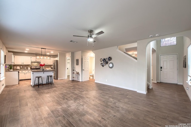 unfurnished living room featuring sink, dark hardwood / wood-style floors, and ceiling fan