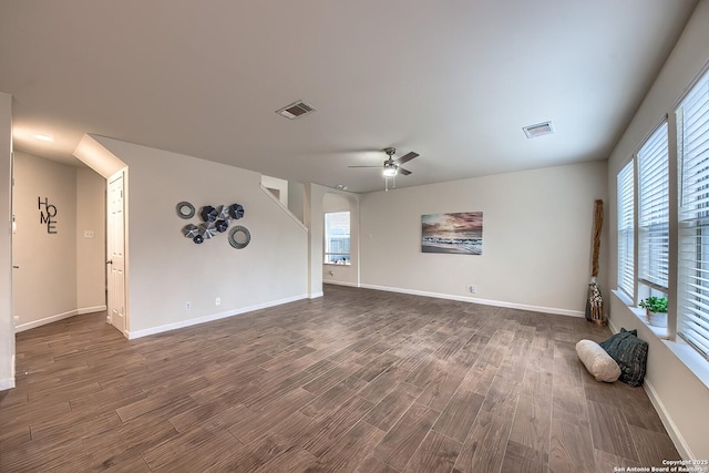 unfurnished living room with dark hardwood / wood-style flooring and ceiling fan