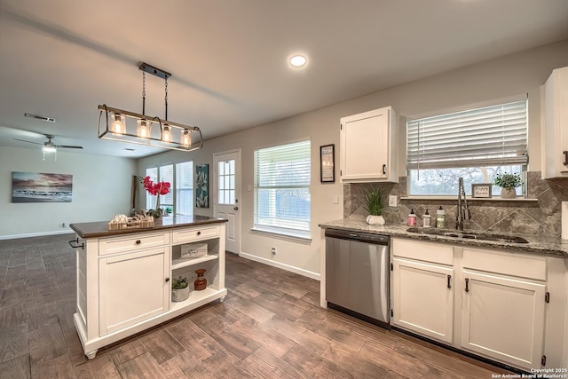 kitchen featuring tasteful backsplash, sink, white cabinets, hanging light fixtures, and stainless steel dishwasher