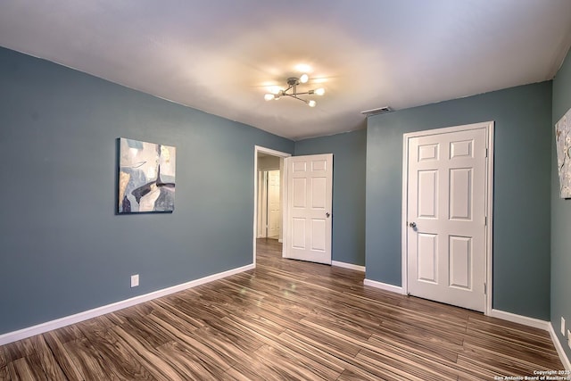 unfurnished bedroom with dark wood-type flooring