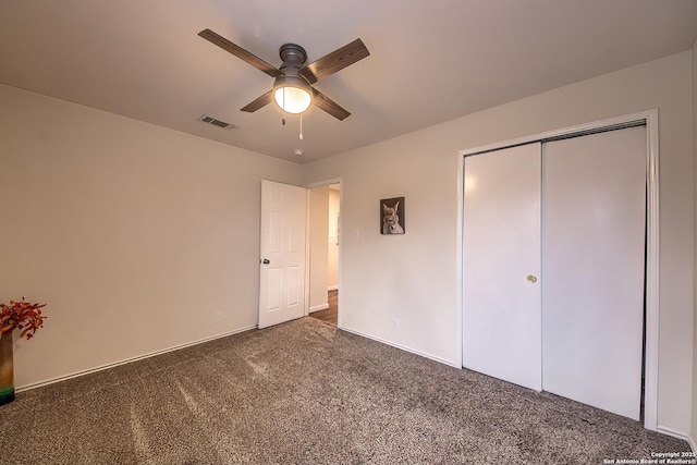 unfurnished bedroom featuring ceiling fan, a closet, and dark colored carpet