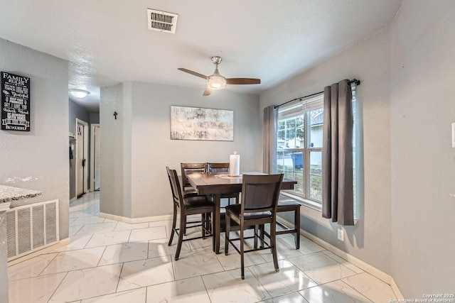 dining space with a textured ceiling and ceiling fan