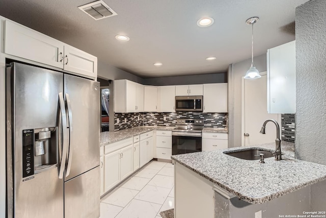 kitchen with pendant lighting, sink, white cabinetry, stainless steel appliances, and decorative backsplash