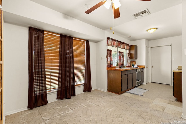 kitchen with dark brown cabinetry, sink, and ceiling fan