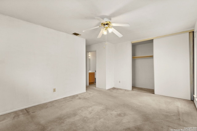 unfurnished bedroom featuring light colored carpet, a closet, and ceiling fan