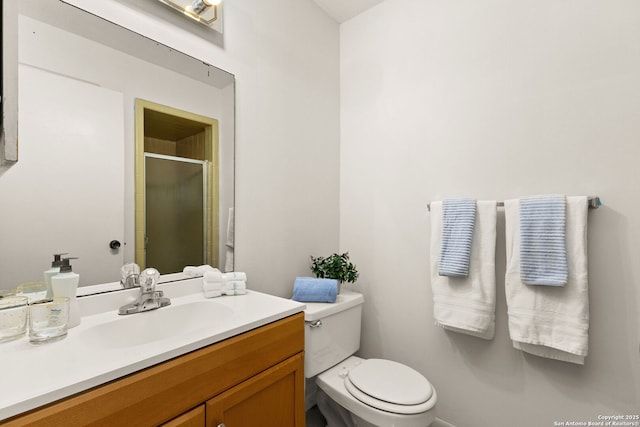 bathroom featuring vanity, toilet, and a shower with door