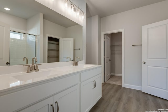 bathroom featuring hardwood / wood-style flooring, vanity, and an enclosed shower